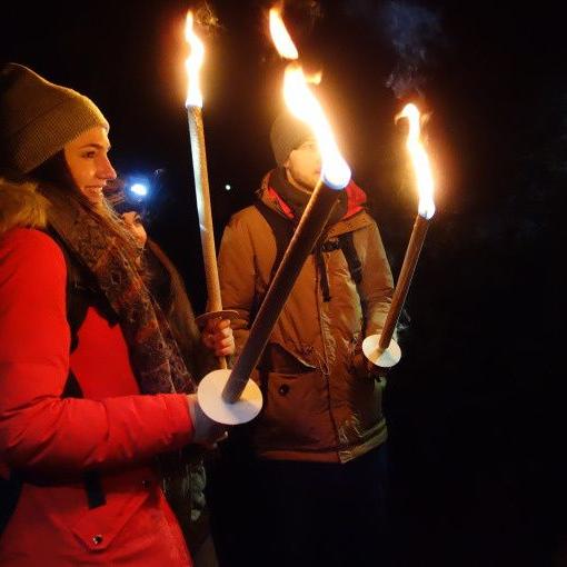 Gruppe mit Fackeln bei einer nächtlichen Winterwanderung in der Ravennaschlucht im Schwarzwald